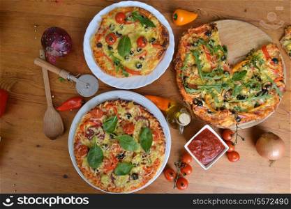 fresh baked pizza with olives and peppers on table