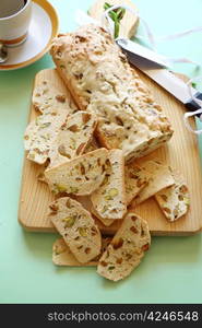 Fresh baked sweet pistachio bread sliced on a bread board ready to serve.