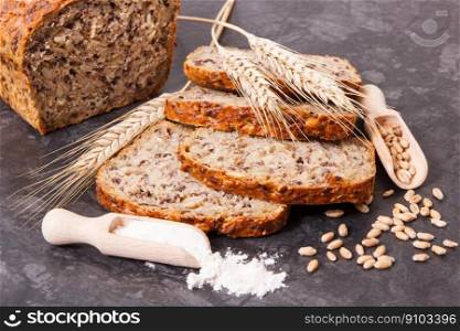 Fresh baked wholegrain bread, ingredients for baking and ears of rye or wheat grain. Wholegrain bread, ingredients for baking and ears of rye or wheat grain