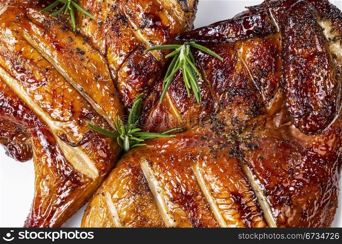 Fresh barbecued smoked half hen chicken with rosemary on top