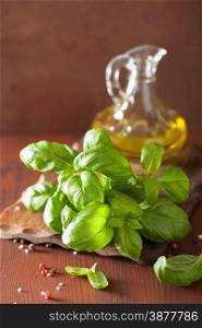 fresh basil leaves herb and olive oil on wooden background