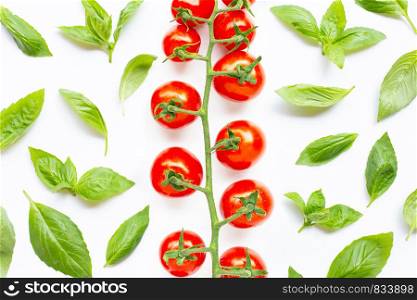 Fresh basil leaves with cherry tomatoes on white background. Top view