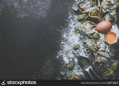 fresh basil tortellini with ingredients on a dark underground, top view