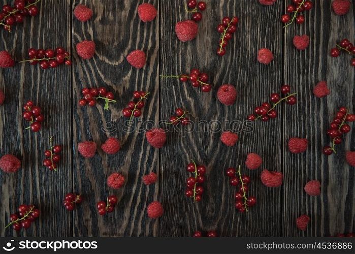 Fresh berries background. Fresh berries raspberry and red currant on wooden table for pattern