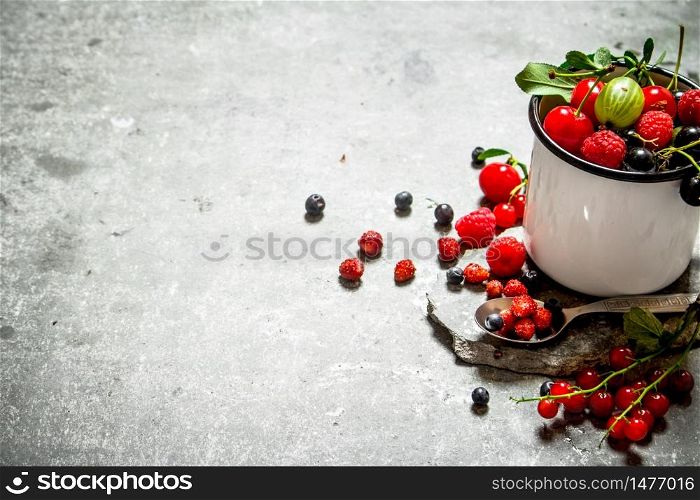 Fresh berries in a cup on a stone stand. On the stone table.. Fresh berry in mug