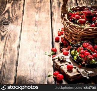 Fresh berries in an old basket. On a wooden table.. Fresh berries in an old basket. On wooden table.