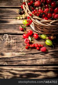 Fresh berries in an old basket. On a wooden table.. Fresh berries in an old basket. On wooden table.