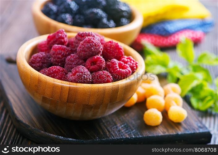 fresh berries in bowl and on a table
