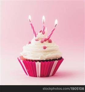 fresh birthday cupcake with burning candles pink backdrop. Beautiful photo. fresh birthday cupcake with burning candles pink backdrop