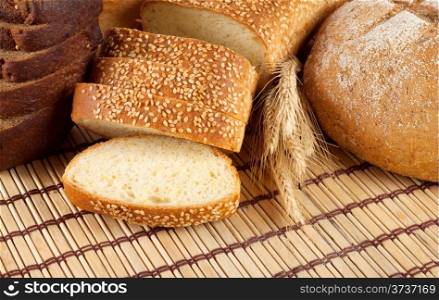 Fresh black and white bread with wheat spikelets