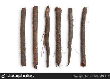 Fresh black salsify in a row on white background