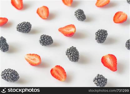 Fresh blackberries and strawberries on the white background