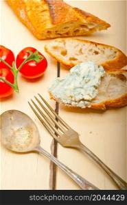 fresh blue cheese spread ove french baguette with cherry tomatoes on side