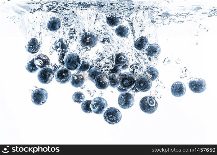Fresh blueberries falling in water on white background. Fruits splashing into clear water. Antioxidant health concept. Fresh blueberries falling in water on white background. Fruits splashing into clear water.
