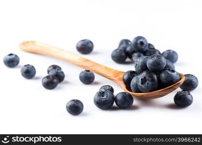 Fresh blueberries in wooden spoon on white background