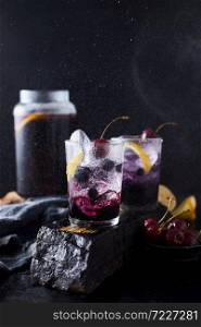Fresh blueberry cocktail with lemon peel and cherry.