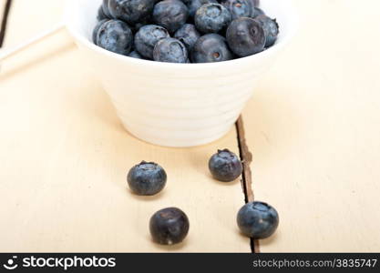 fresh blueberry on a bowl with silver spoon over wood table