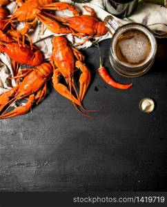 Fresh boiled crawfish with beer on the old fabric. On a black chalkboard.. Fresh boiled crawfish with beer on the old fabric.