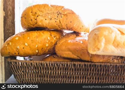 fresh bread buns in a basket on a wooden table