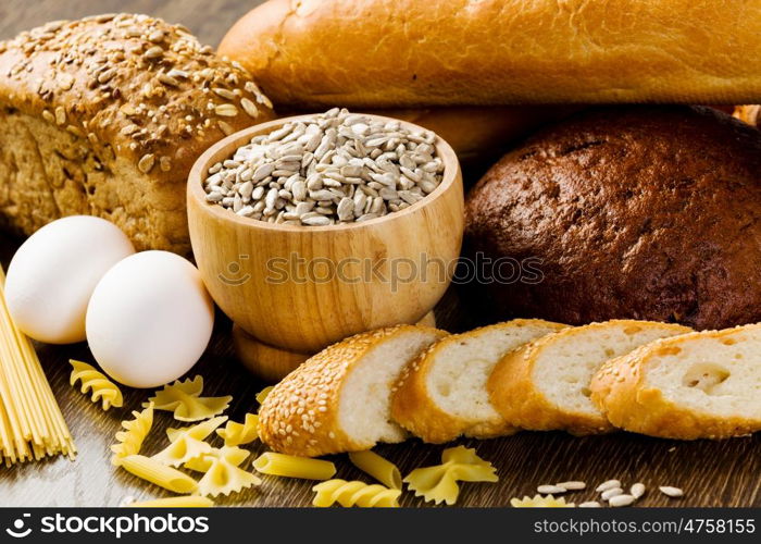 Fresh bread, eggs and macaroni on table