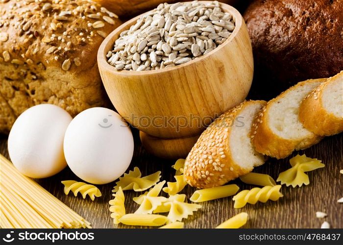 Fresh bread, eggs and macaroni on table