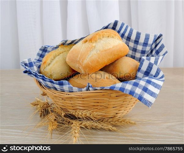 Fresh bread in a basket with a cloth cover ears of wheat