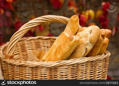 Fresh bread in the basket on a background autumn leaves
