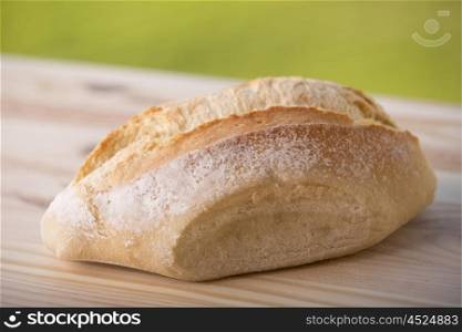 Fresh bread on wooden table, on nature background