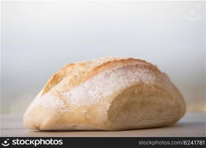Fresh bread on wooden table, on nature background