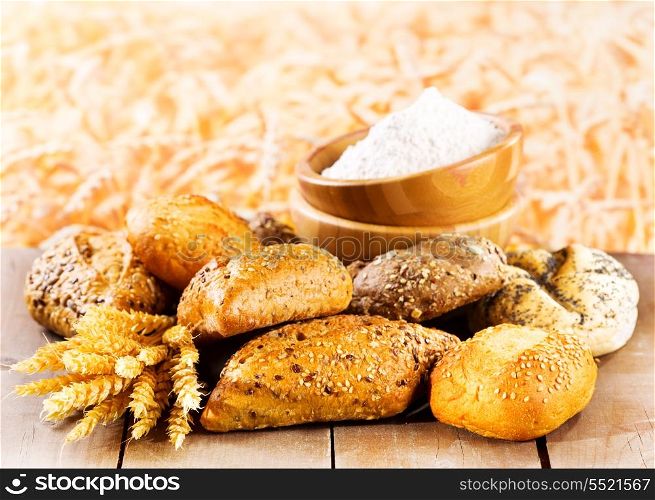 fresh bread with wheat ears on wooden table