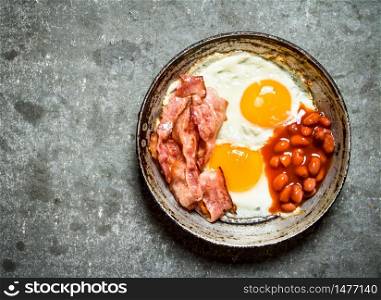 fresh Breakfast. Fried bacon with eggs and red beans. On the stone table.. fresh Breakfast. Fried bacon with eggs and red beans.