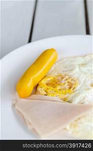 fresh breakfast - fried egg , ham and sausage on white dish