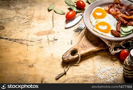 fresh Breakfast plate. Fried eggs with bacon and tomatoes. On a wooden table.. fresh Breakfast plate. Fried eggs with bacon and tomatoes.