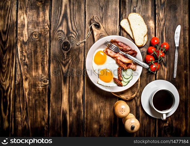Fresh Breakfast with Cup of coffee, fried Beck with eggs and tomatoes. On a wooden table.. Fresh Breakfast with Cup of coffee