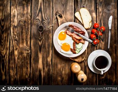Fresh Breakfast with Cup of coffee, fried Beck with eggs and tomatoes. On a wooden table.. Fresh Breakfast with Cup of coffee