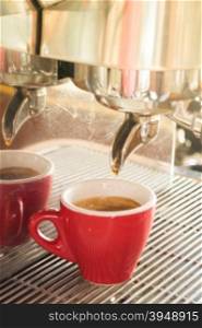 Fresh brewing hot coffee from espresso machine with vintage filter effect, stock photo