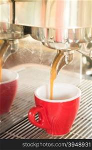 Fresh brewing hot coffee from espresso machine with vintage filter effect, stock photo