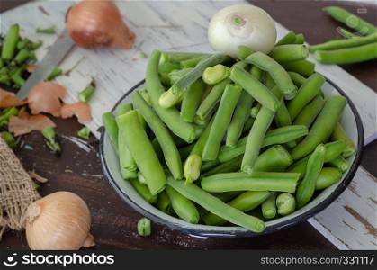 Fresh broad beans over wood background, selective focus