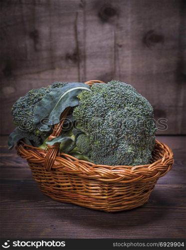 fresh broccoli in a brown wicker basket, empty space on top