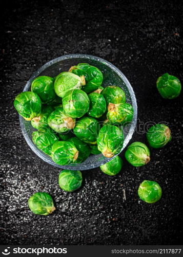 Fresh Brussels cabbage in a glass bowl. On a black background. High quality photo. Fresh Brussels cabbage in a glass bowl.