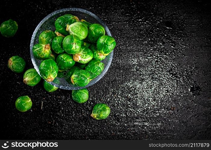 Fresh Brussels cabbage in a glass bowl. On a black background. High quality photo. Fresh Brussels cabbage in a glass bowl.
