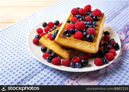Fresh brussels waffle with blueberry, raspberry and blackcurrant. Breakfast soft waffles with fresh berries. Fresh brussels waffle with blueberry, raspberry and blackcurrant