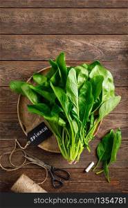 Fresh bundle of spinach on rustic wooden background