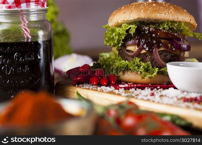 Fresh burger closeup on wooden desk background. Close-up of home made burgers, wooden desk background