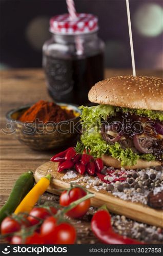 Fresh burger closeup on wooden desk background. Close-up of home made burgers, wooden desk background