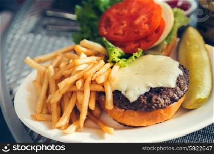 Fresh burger with cheeseand french fries outdoors