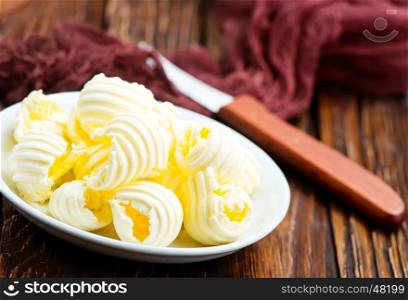 fresh butter on plate and on a table
