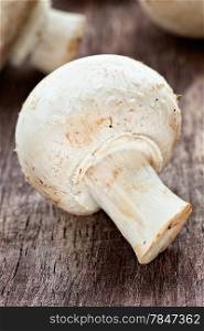 Fresh button mushroom on wooden background, closeup, selective focus