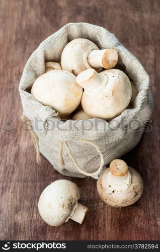 Fresh button mushrooms on wooden background, selective focus