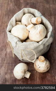 Fresh button mushrooms on wooden background, selective focus